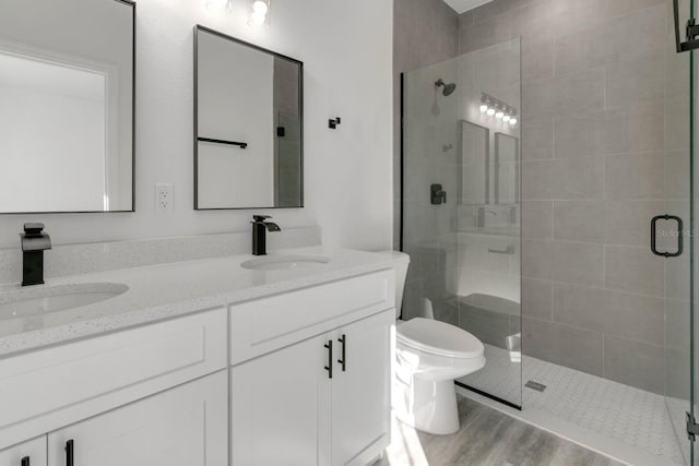 bathroom featuring vanity, wood-type flooring, toilet, and walk in shower