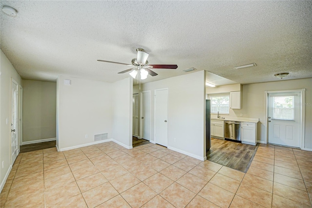 interior space featuring light tile patterned flooring, sink, a textured ceiling, and ceiling fan