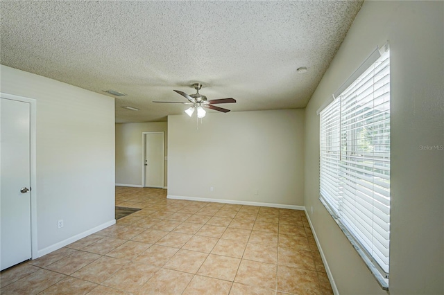 tiled empty room featuring a textured ceiling and ceiling fan