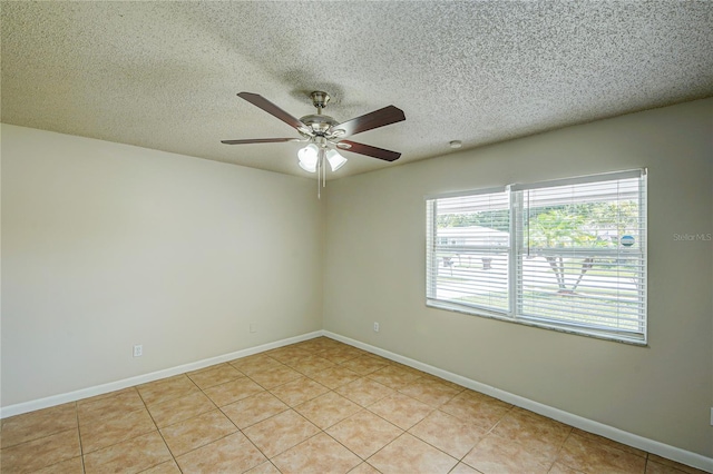 tiled empty room with ceiling fan and a textured ceiling