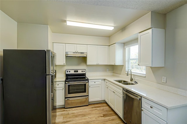 kitchen featuring white cabinetry, appliances with stainless steel finishes, sink, and light hardwood / wood-style floors