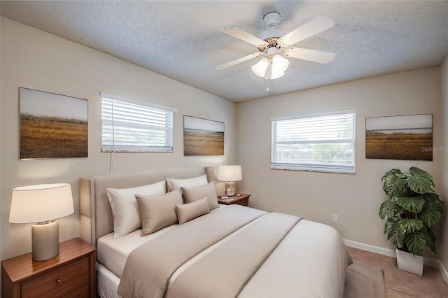 bedroom with ceiling fan and a textured ceiling