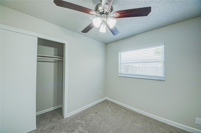 unfurnished bedroom featuring ceiling fan, light carpet, a textured ceiling, and a closet