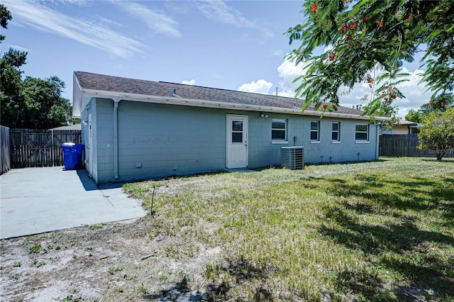 back of property with a patio, central AC unit, and a lawn