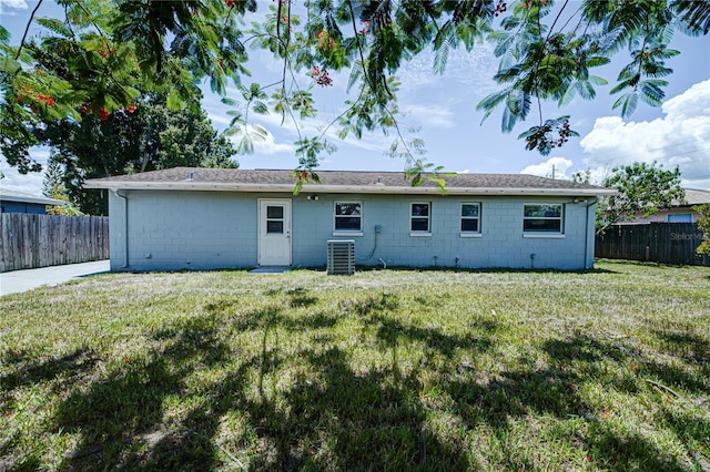 back of property featuring cooling unit and a lawn