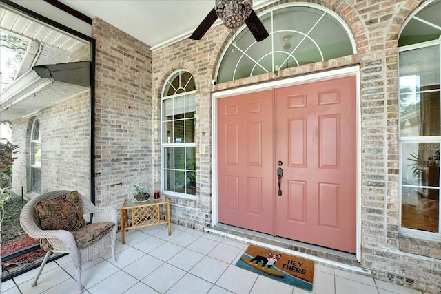 view of exterior entry with a porch and ceiling fan