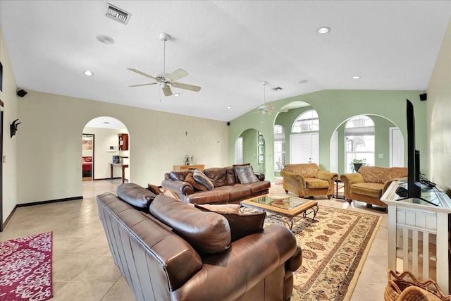 living room with lofted ceiling, ceiling fan, and light tile patterned flooring