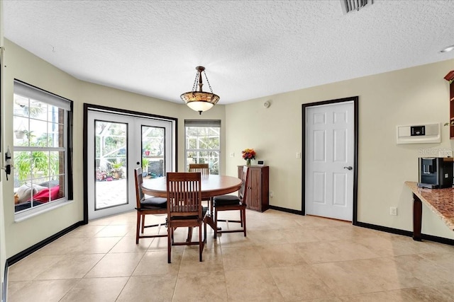 dining space with a textured ceiling and light tile patterned floors