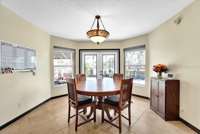 tiled dining room featuring french doors and a textured ceiling