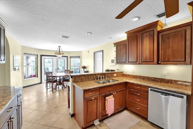 kitchen featuring sink, hanging light fixtures, light tile patterned floors, dishwasher, and kitchen peninsula