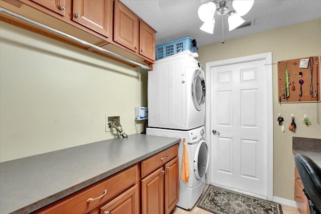 laundry room with stacked washer and dryer and a textured ceiling