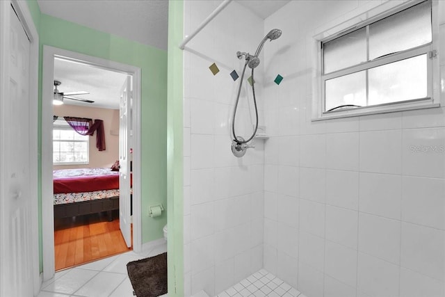 bathroom featuring tile patterned flooring, tiled shower, and toilet