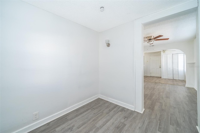 empty room featuring ceiling fan, a textured ceiling, and light hardwood / wood-style floors