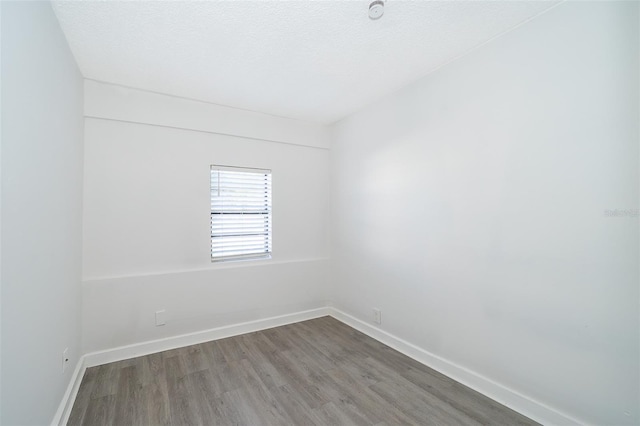 unfurnished room with wood-type flooring and a textured ceiling