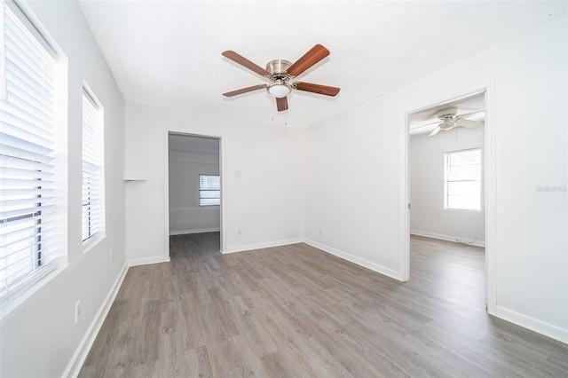 unfurnished room with ceiling fan, light hardwood / wood-style floors, and a textured ceiling