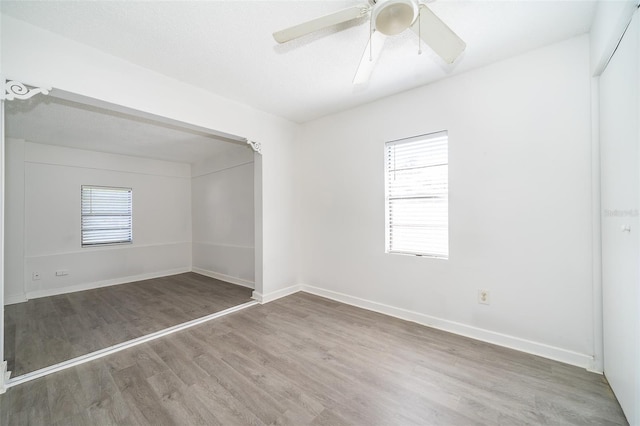 unfurnished room with ceiling fan, a healthy amount of sunlight, and wood-type flooring