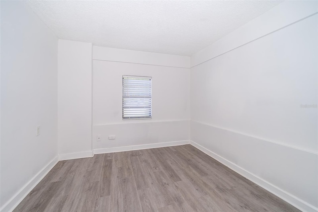 unfurnished room with light hardwood / wood-style floors and a textured ceiling