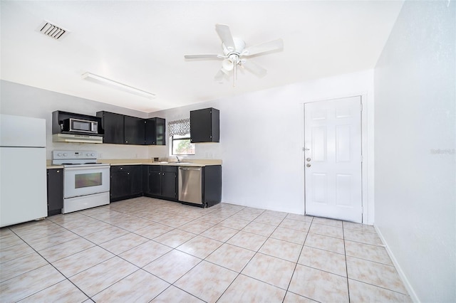 kitchen with sink, white appliances, light tile patterned floors, and ceiling fan