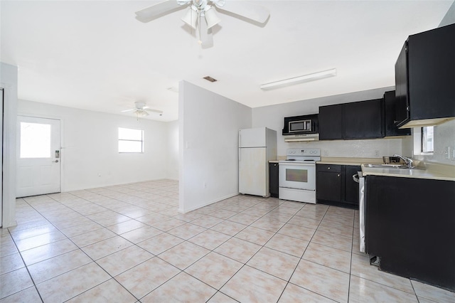 kitchen with light tile patterned floors, white appliances, sink, and ceiling fan