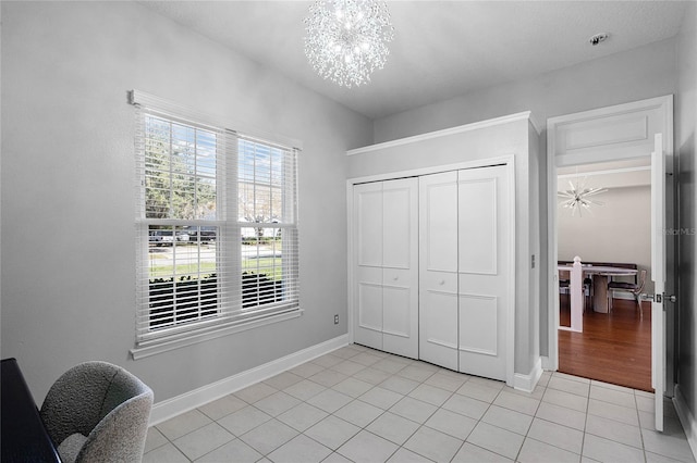 tiled bedroom with a notable chandelier and a closet