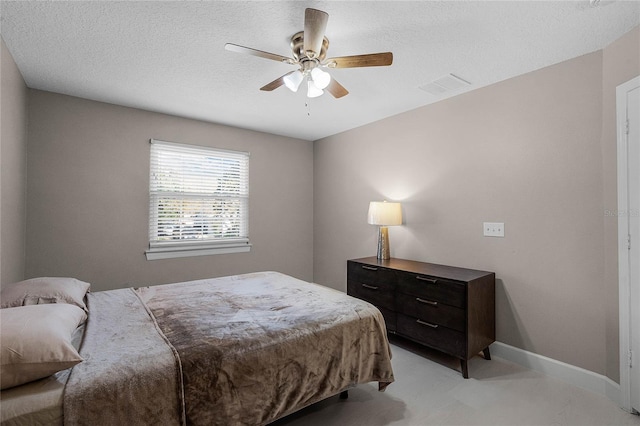 bedroom with ceiling fan and a textured ceiling