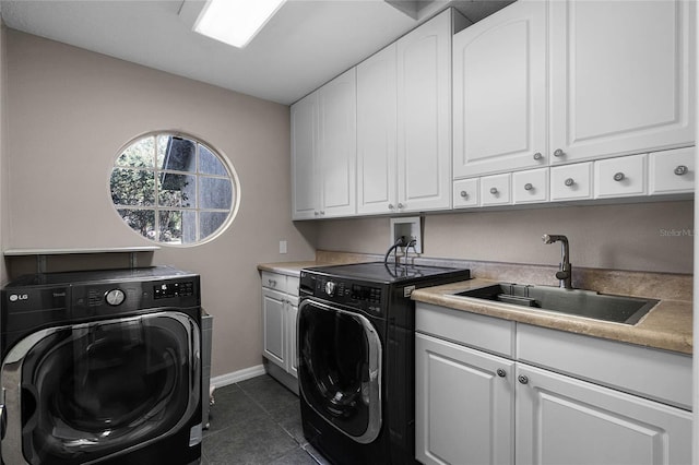 laundry area with cabinets, washing machine and dryer, sink, and dark tile patterned floors