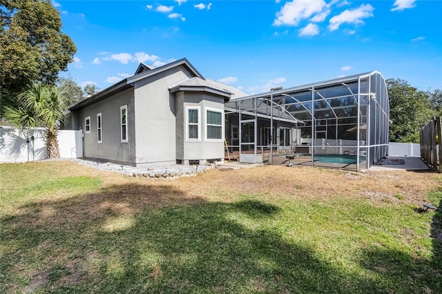 back of house featuring a fenced in pool, a lanai, and a yard