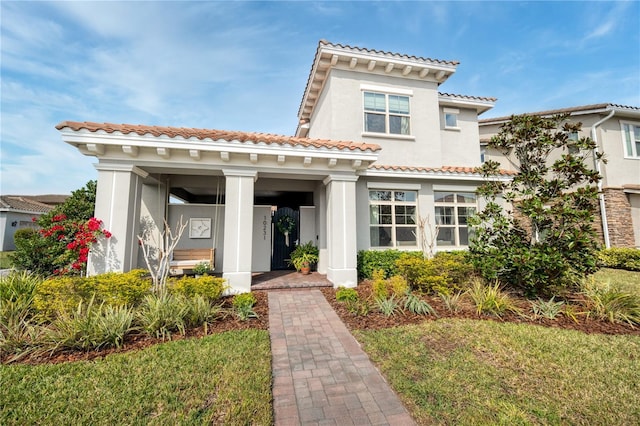 mediterranean / spanish-style house with a front lawn