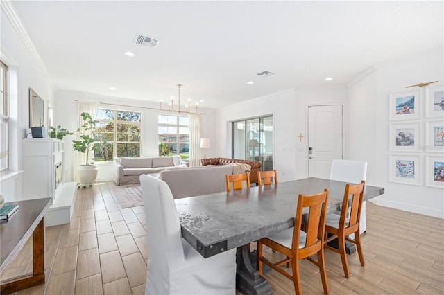 dining space with an inviting chandelier, ornamental molding, and light hardwood / wood-style floors