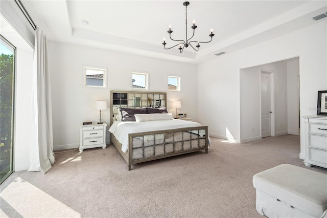 bedroom with light colored carpet, a raised ceiling, and multiple windows