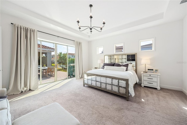 bedroom with access to exterior, carpet floors, a raised ceiling, and a chandelier