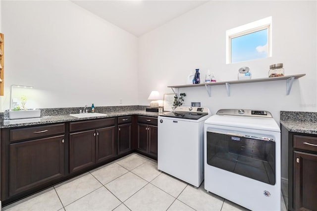 clothes washing area featuring separate washer and dryer, sink, cabinets, and light tile patterned flooring