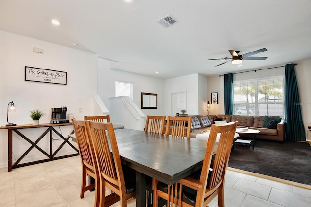 tiled dining room with plenty of natural light and ceiling fan