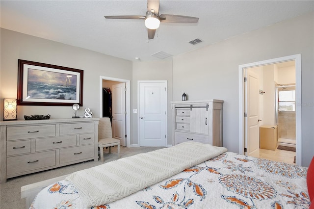 carpeted bedroom with ceiling fan, ensuite bathroom, and a textured ceiling