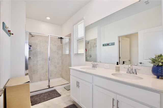 bathroom featuring a shower with door, vanity, and tile patterned flooring