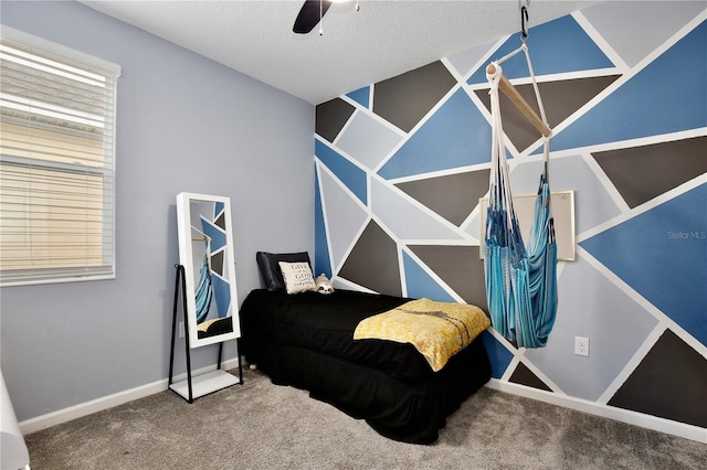 carpeted bedroom with ceiling fan and a textured ceiling