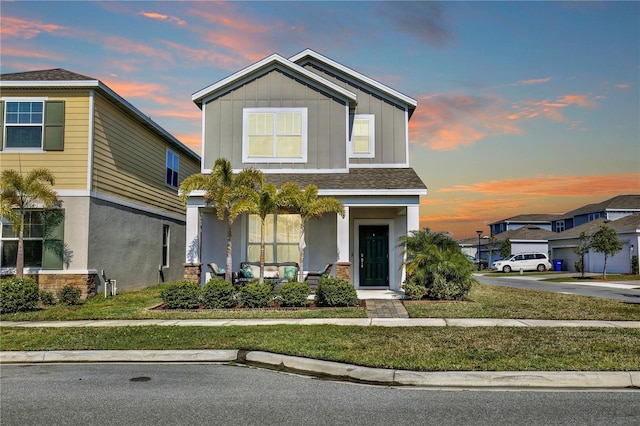 2429 Volunteer Ave, Kissimmee, FL 34744 - traditional-style home with covered porch, stucco siding, a front lawn, and board and batten siding