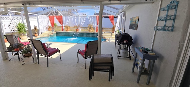 view of pool with a patio, pool water feature, and glass enclosure