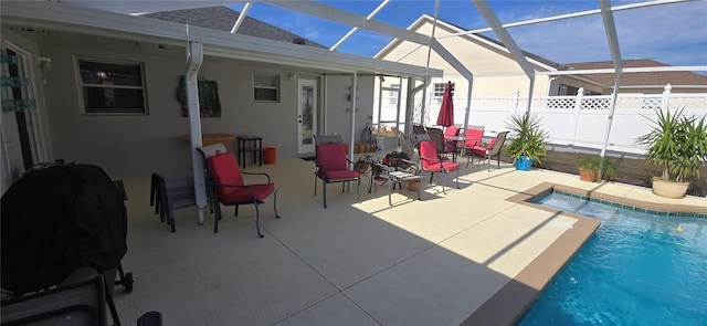 view of swimming pool with glass enclosure and a patio area