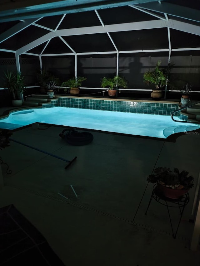 view of swimming pool featuring a lanai