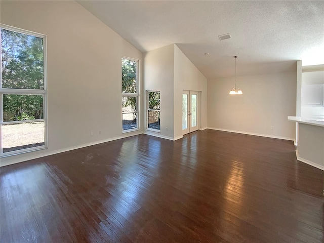 unfurnished living room with high vaulted ceiling, a chandelier, a textured ceiling, and dark hardwood / wood-style flooring