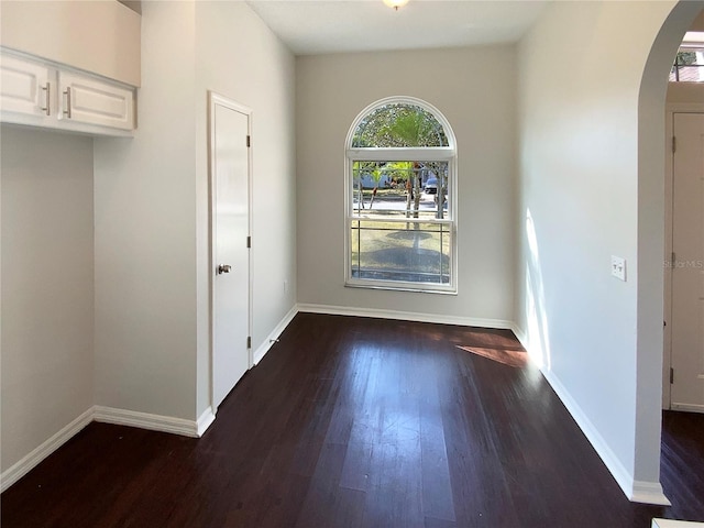 unfurnished dining area featuring dark wood-type flooring