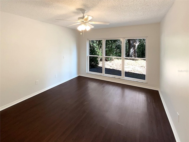 unfurnished room with ceiling fan, a textured ceiling, and dark hardwood / wood-style flooring