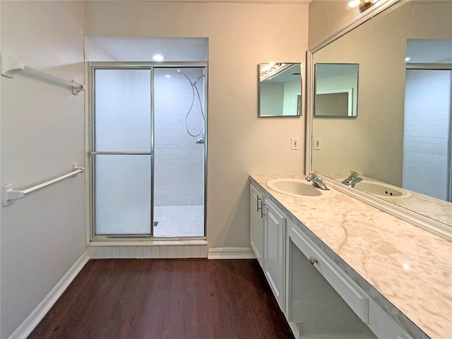 bathroom with hardwood / wood-style flooring, vanity, and walk in shower