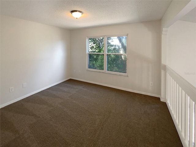 carpeted spare room with a textured ceiling