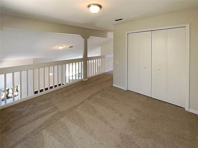 interior space featuring carpet flooring and a textured ceiling