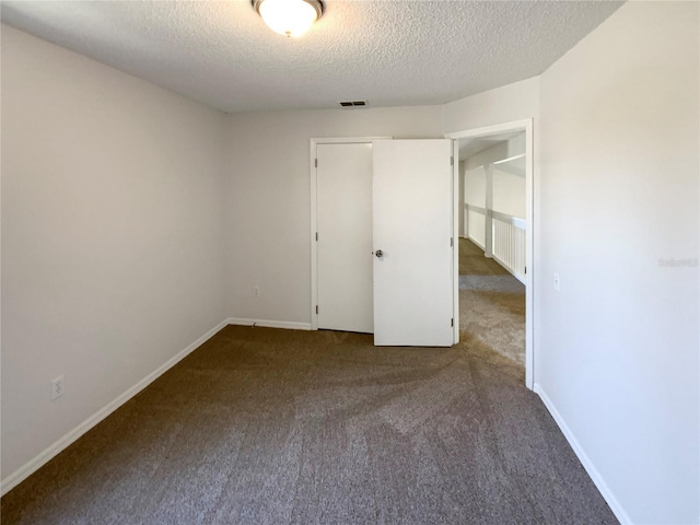 unfurnished bedroom featuring carpet floors and a textured ceiling