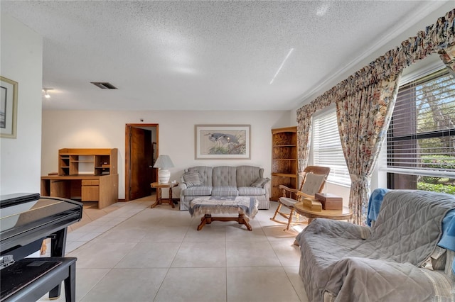 living room featuring light tile patterned floors, visible vents, and a textured ceiling