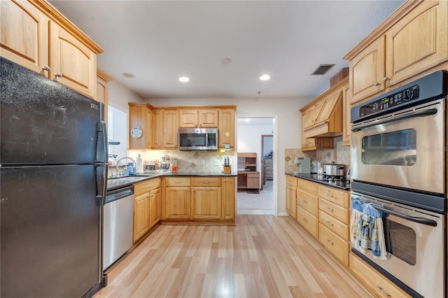 kitchen featuring black appliances and light brown cabinets