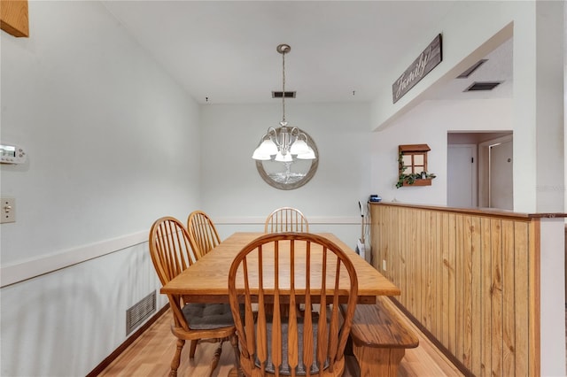 dining room with light wood-style floors, visible vents, and an inviting chandelier